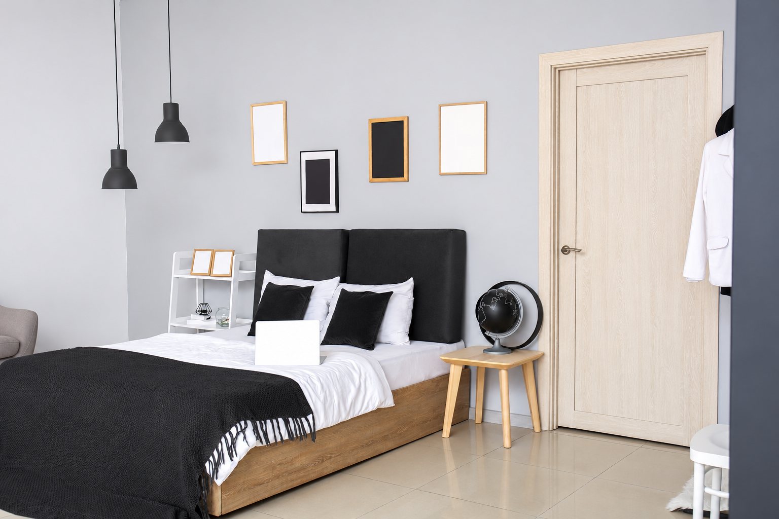 Chambre aux murs gris clair avec un lit à tête de lit noire, une table de chevet en bois, un globe décoratif et une porte en bois clair.
